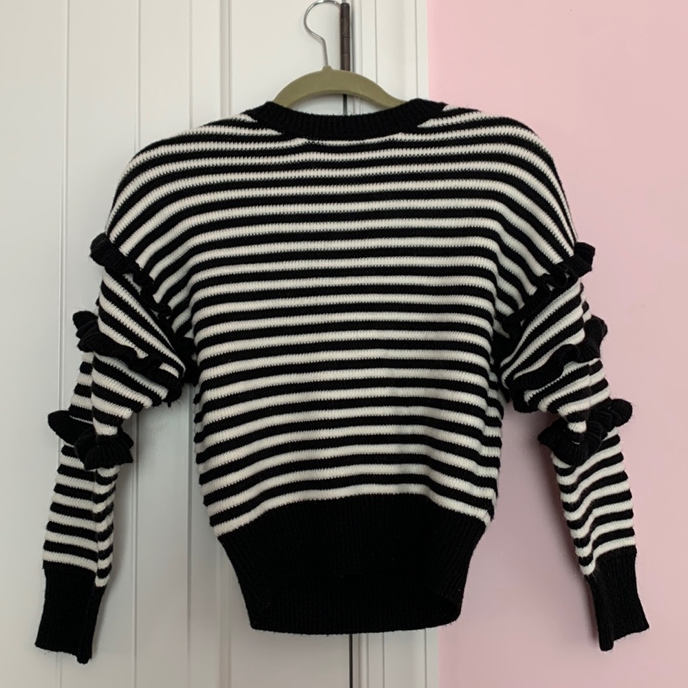 Cotton Emporium black and white sweater. Ruffled sleeves, soft material.